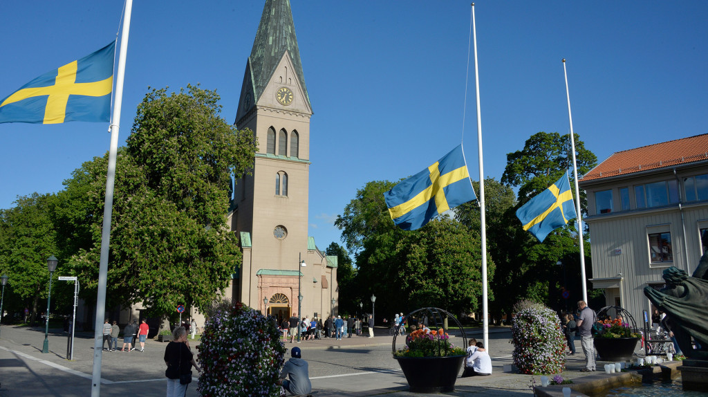 Minnesstund. Utanför S:ta Helena-kyrkan i Skövde vajar flaggorna på halv stång. Foto: Roger Lundsten